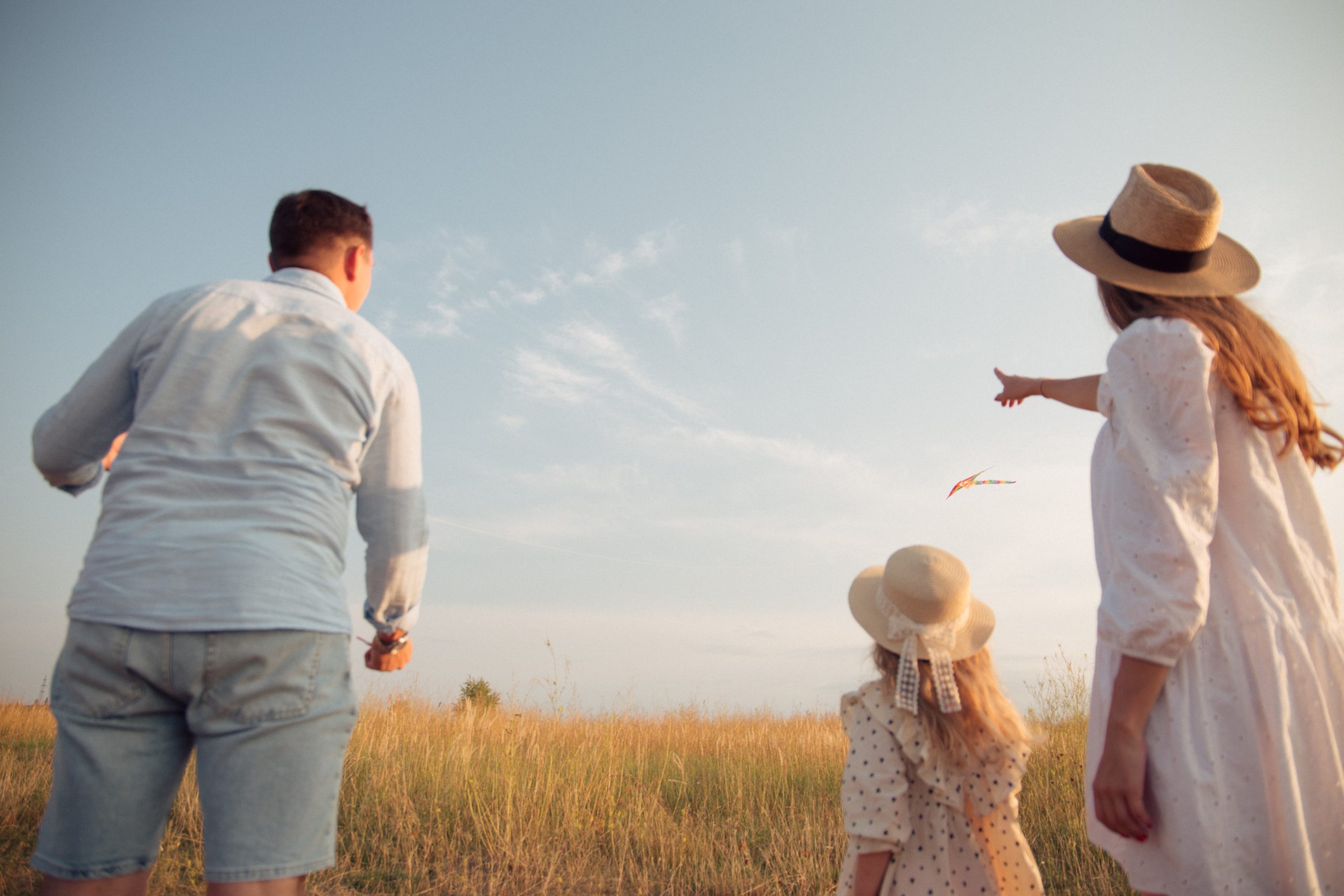 Una famiglia composta da papà, figlia e mamma che guardano l'orizzonte