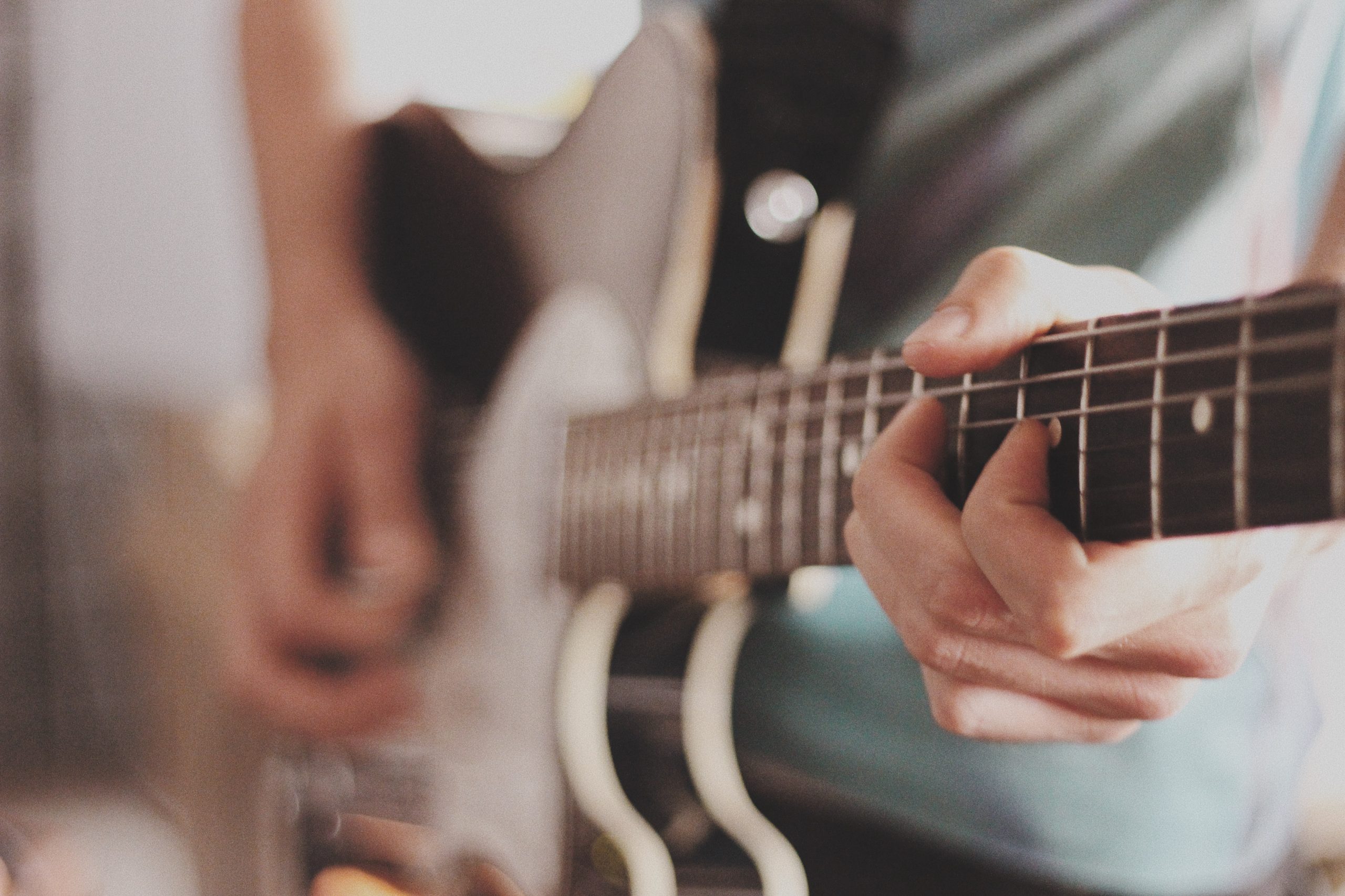 Foto ravvicinata di una chitarra elettrica mentre viene suonata.