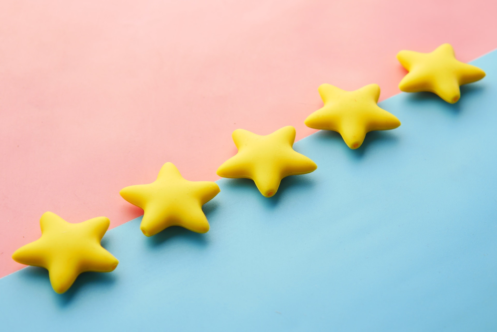 Una fila di stelle gialle sedute in cima a una superficie blu e rosa